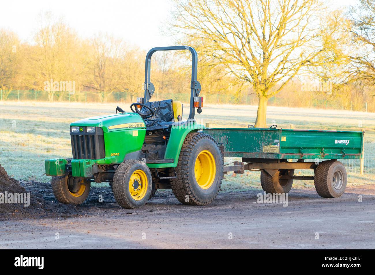 small green tractor and trailer used for grounds maintenance a cold