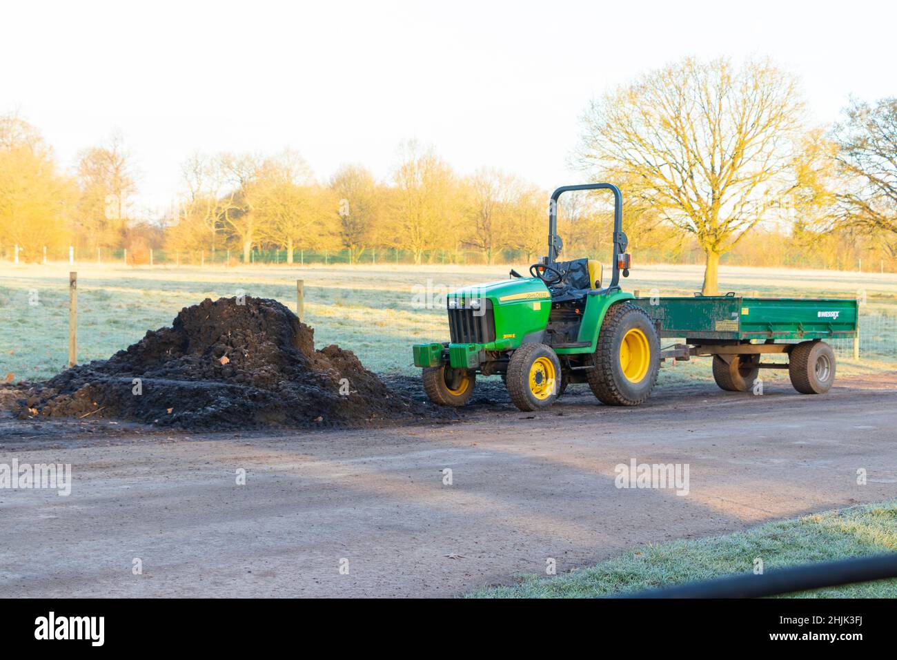 small green tractor and trailer used for grounds maintenance a cold