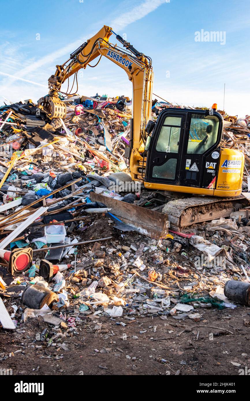 CAT or caterpillar excavator parked on a scrap heap at a junk yard in