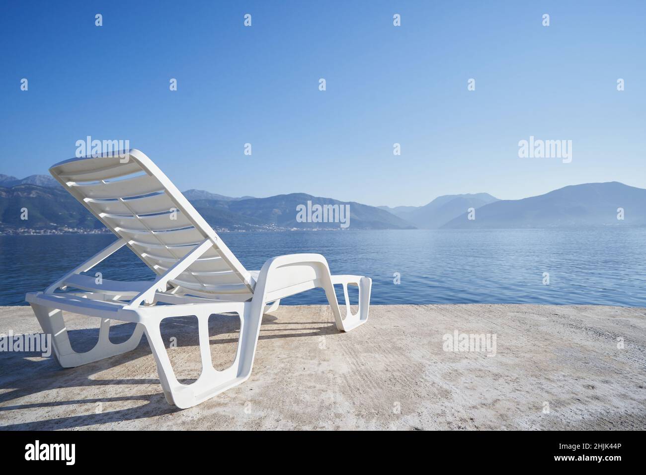 Beach chair on the background of the sea and mountains in Montenegro. Stock Photo