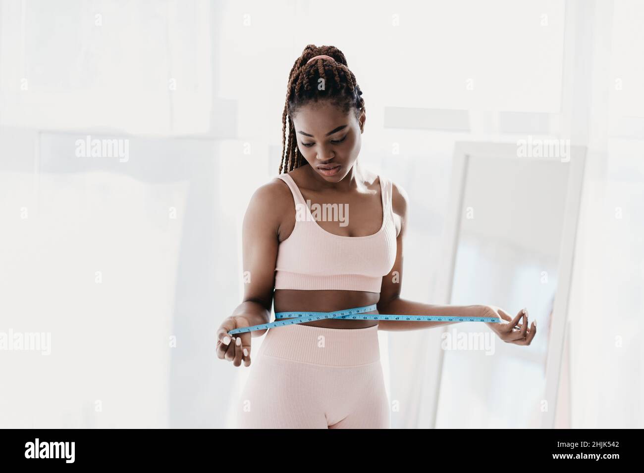 https://c8.alamy.com/comp/2HJK542/unhappy-young-black-woman-measuring-waist-with-tape-feeling-upset-with-results-of-slimming-diet-not-losing-weight-2HJK542.jpg