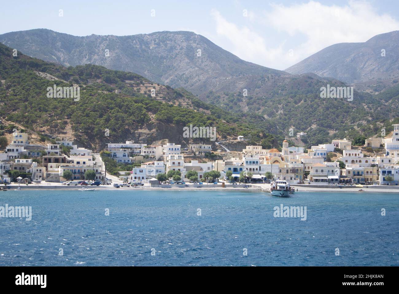 Diafani port,  Karpathos island - Greece - August 26 2014 : .Panoramic view of the charming town, with pine-clad dramatic hills as background.  Landsc Stock Photo