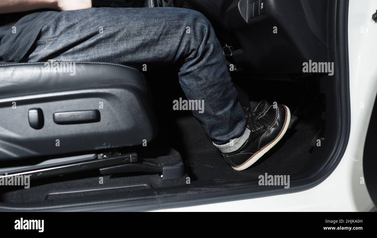 Accelerate and Brake. Foot pressing foot pedal of a car to drive ahead