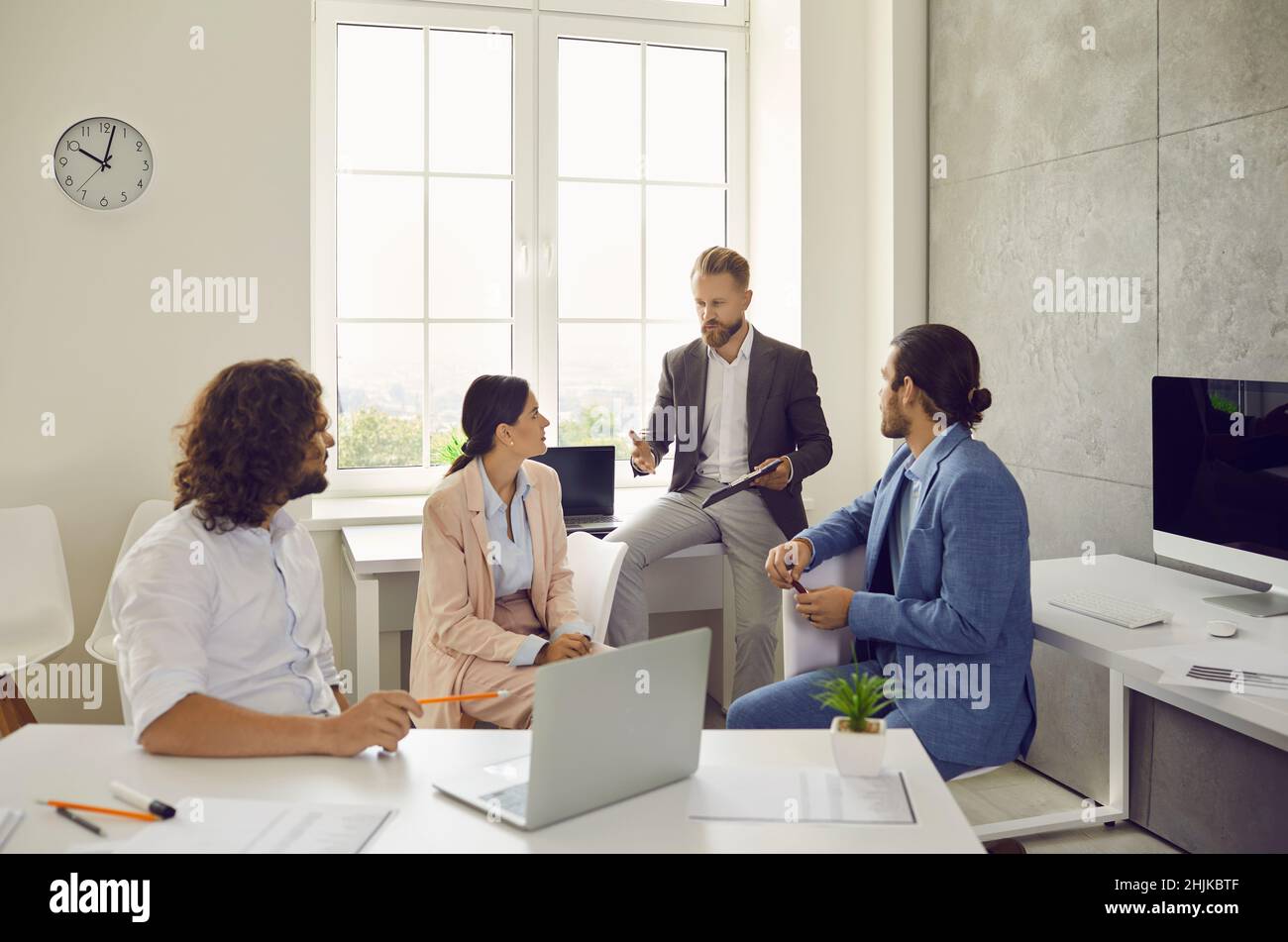 Serious confident business colleagues together discuss project at meeting in office. Stock Photo