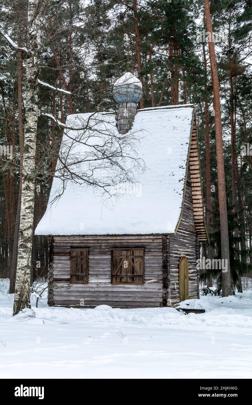 Old wooden log orthodox church covered with snow in a winter forest. Stock Photo