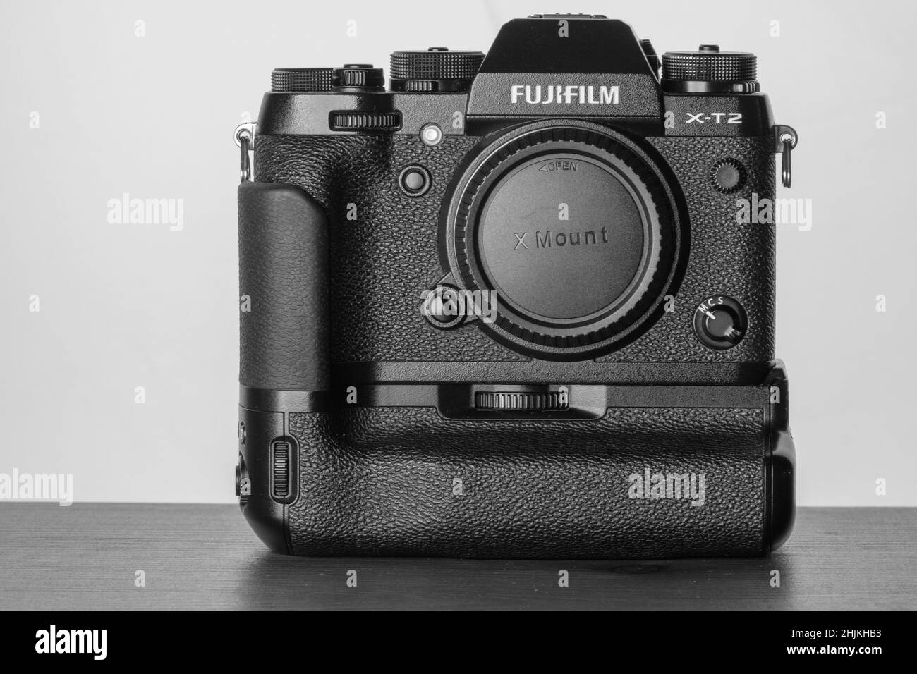 View of the mirrorless Fuji film aps-c camera with a battery grip on in black and white Stock Photo