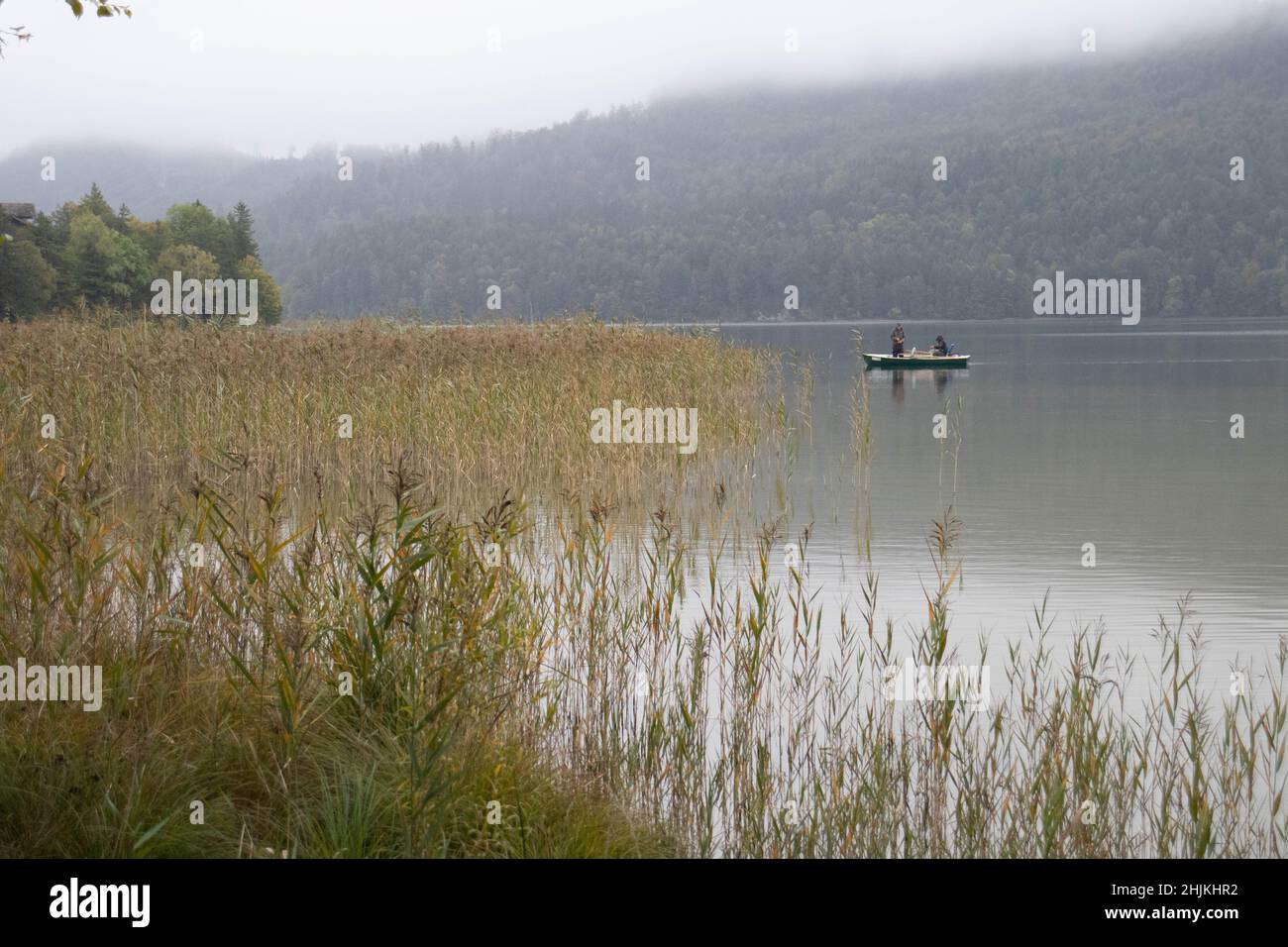 Bei Nebel und Nieselregen versuchen zwei Angler ihr Glück auf dem Weissensee in Füssen Stock Photo