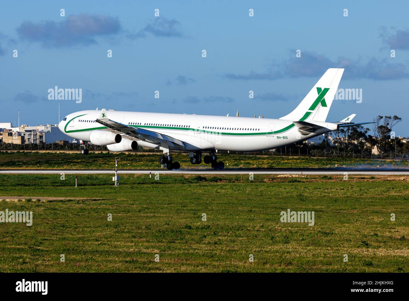 Air X Charter Airbus A340-313X (Reg.: 9H-BIG) landing runway 31 in the evening. Stock Photo
