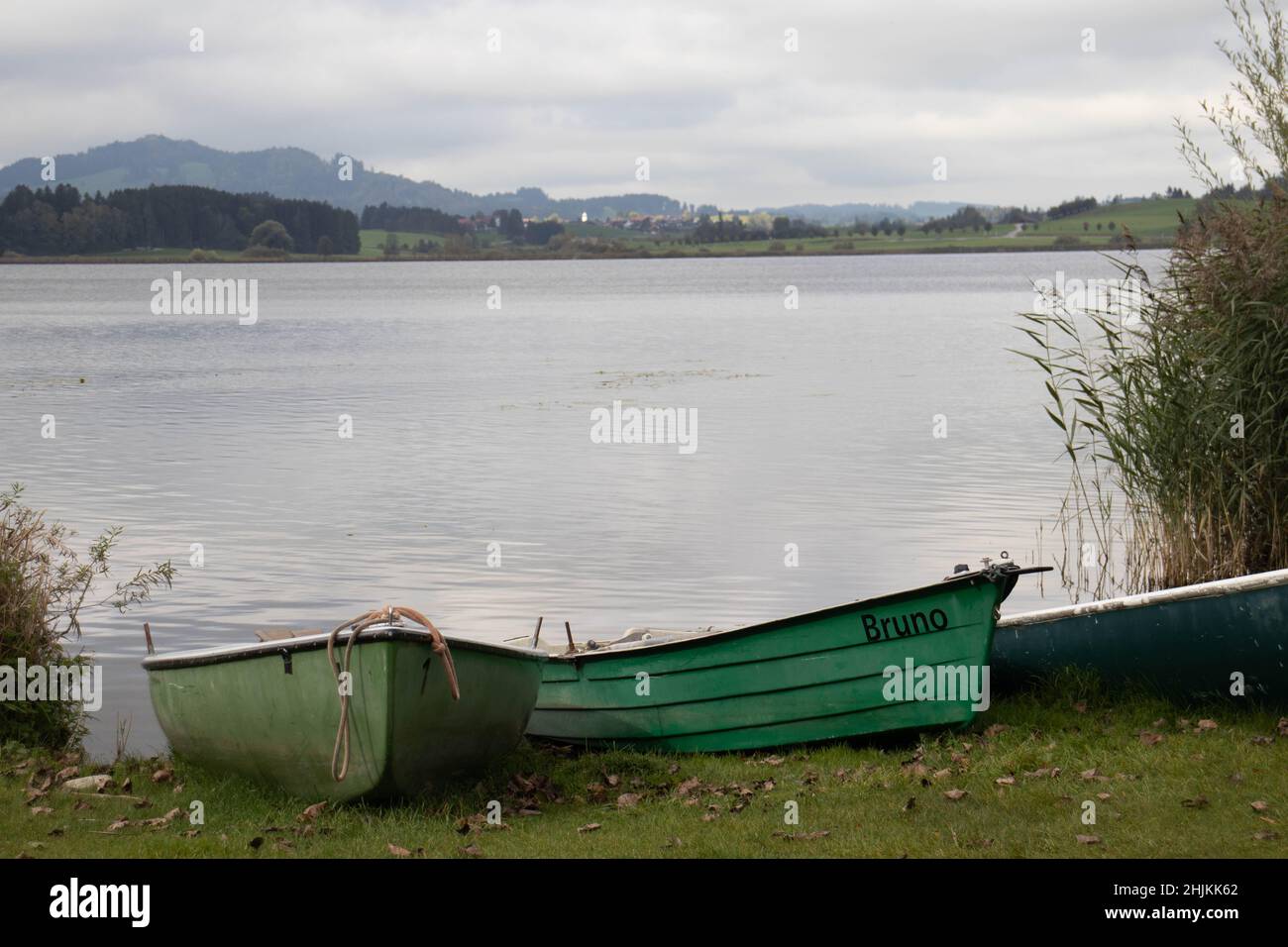 Grüne Ruderboote liegen an Land und warten auf Angler oder Touristen, die auf dem Hopfensee rudern möchten Stock Photo