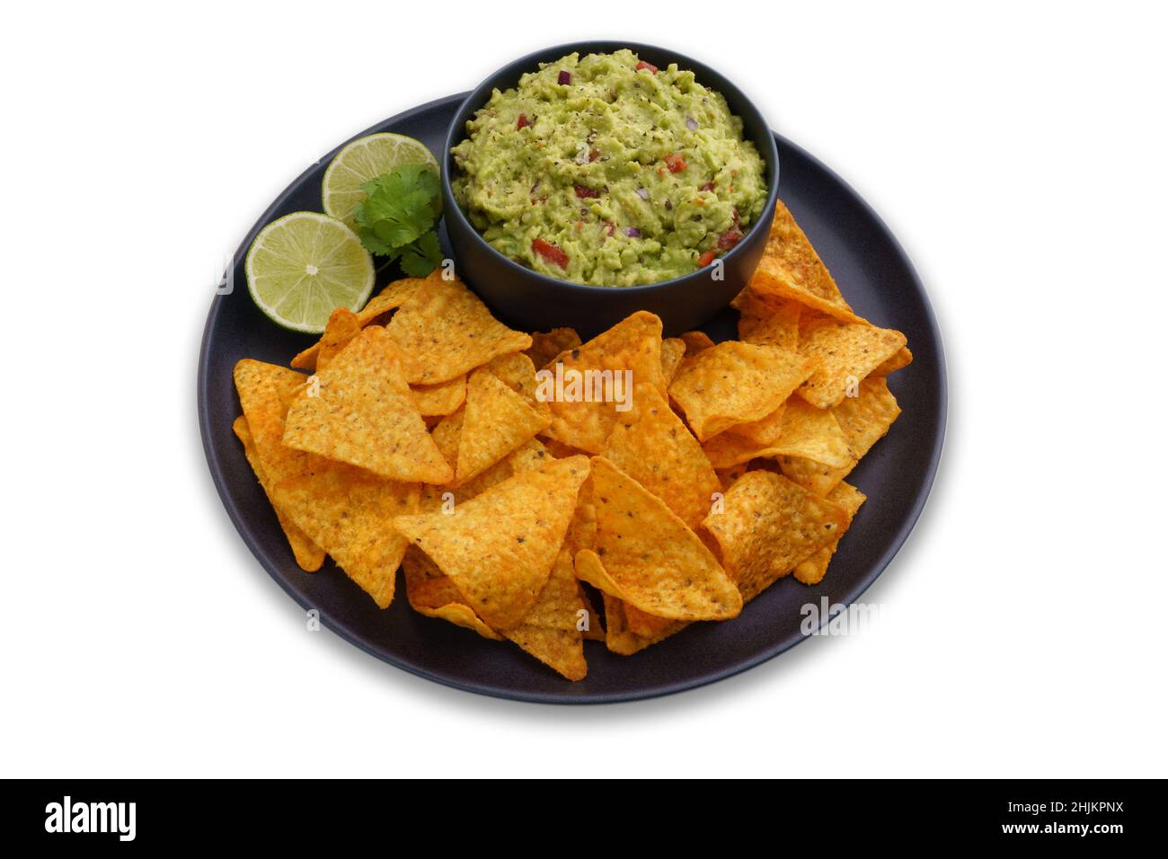 Black plate of guacamole dip and tortilla chips or nachos isolated on a white background Stock Photo