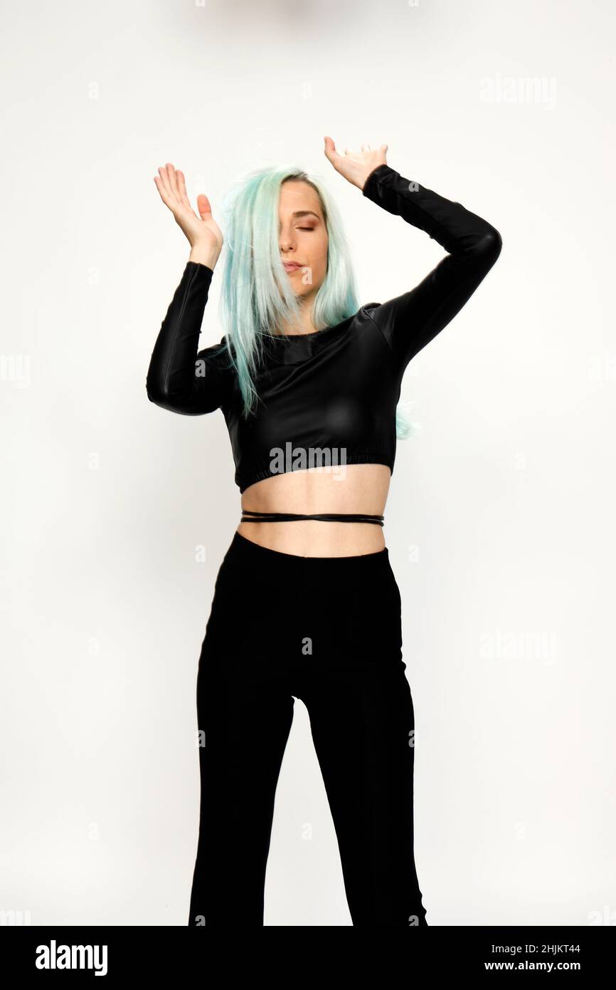 Beautiful girl with blue hair is posing in studio on isolated background. Style, trends, fashion concept. Stock Photo