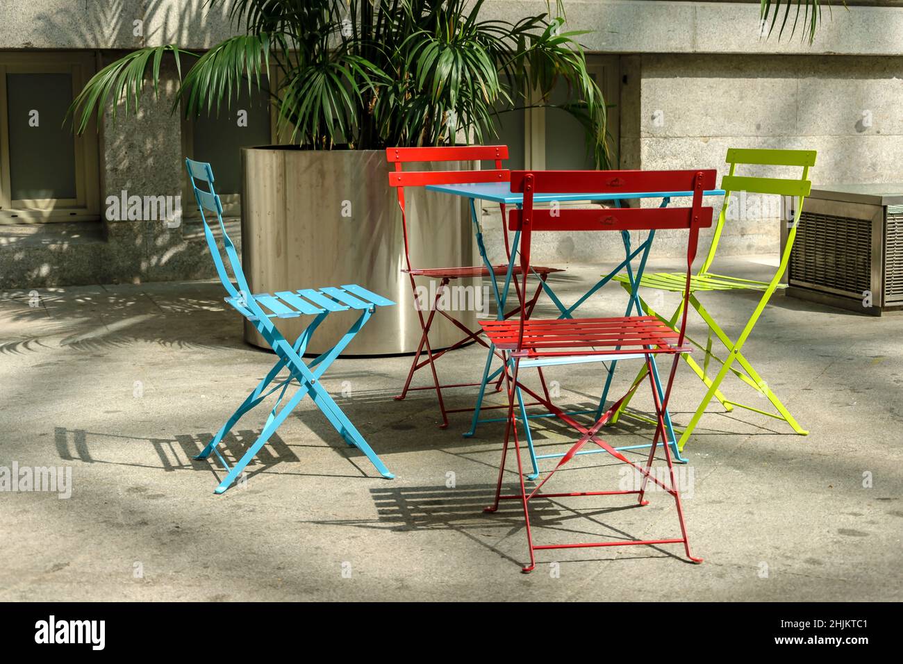 Four empty colored chairs on a terrace of an interior patio at sunset