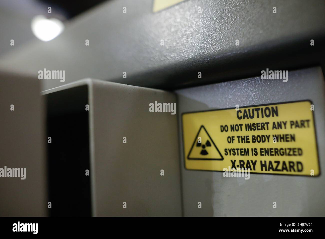 Shallow depth of field (selective focus) details with the Caution message on an X-ray baggage scanner machine. Stock Photo