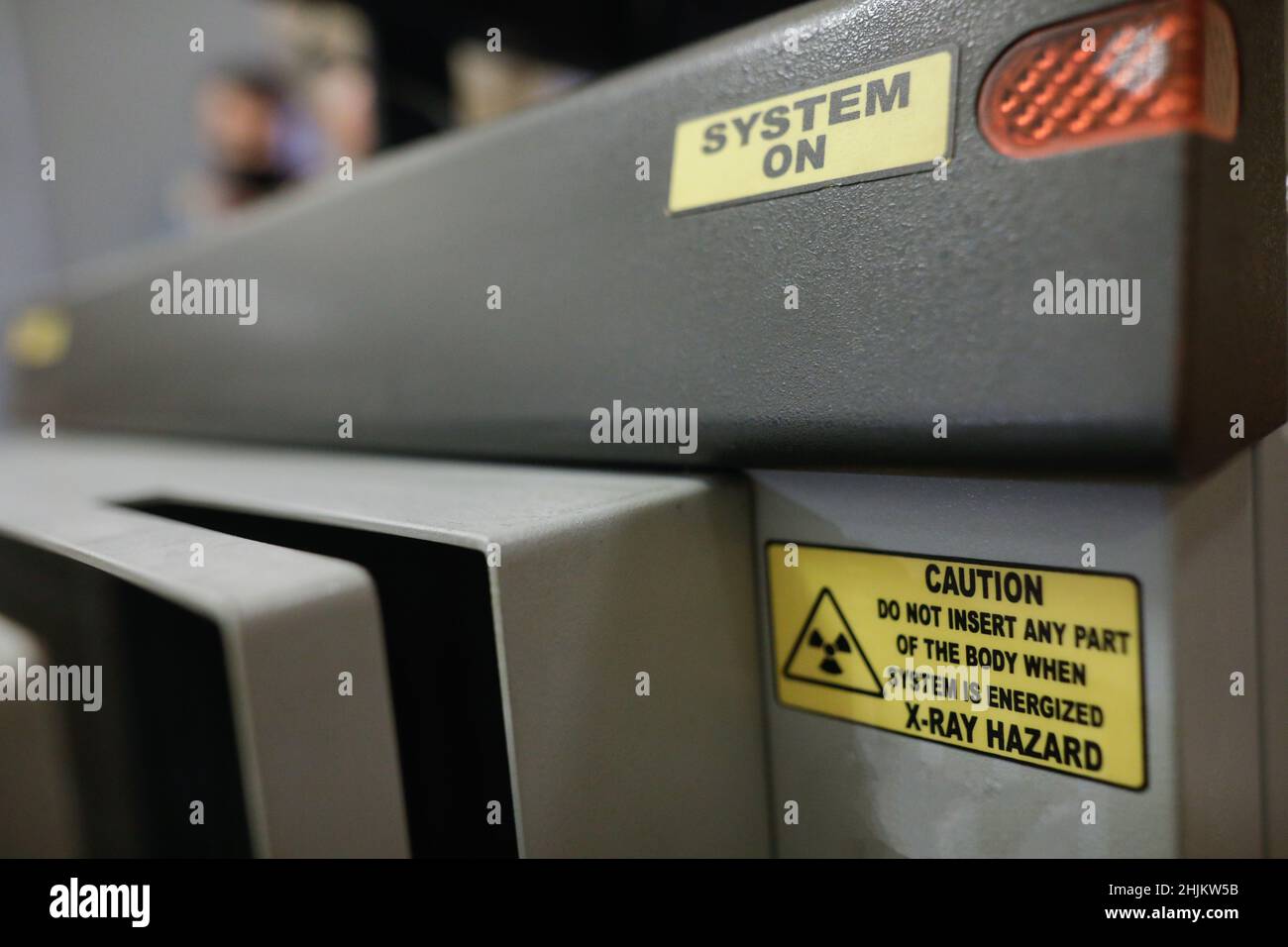 Shallow depth of field (selective focus) details with the Caution message on an X-ray baggage scanner machine. Stock Photo