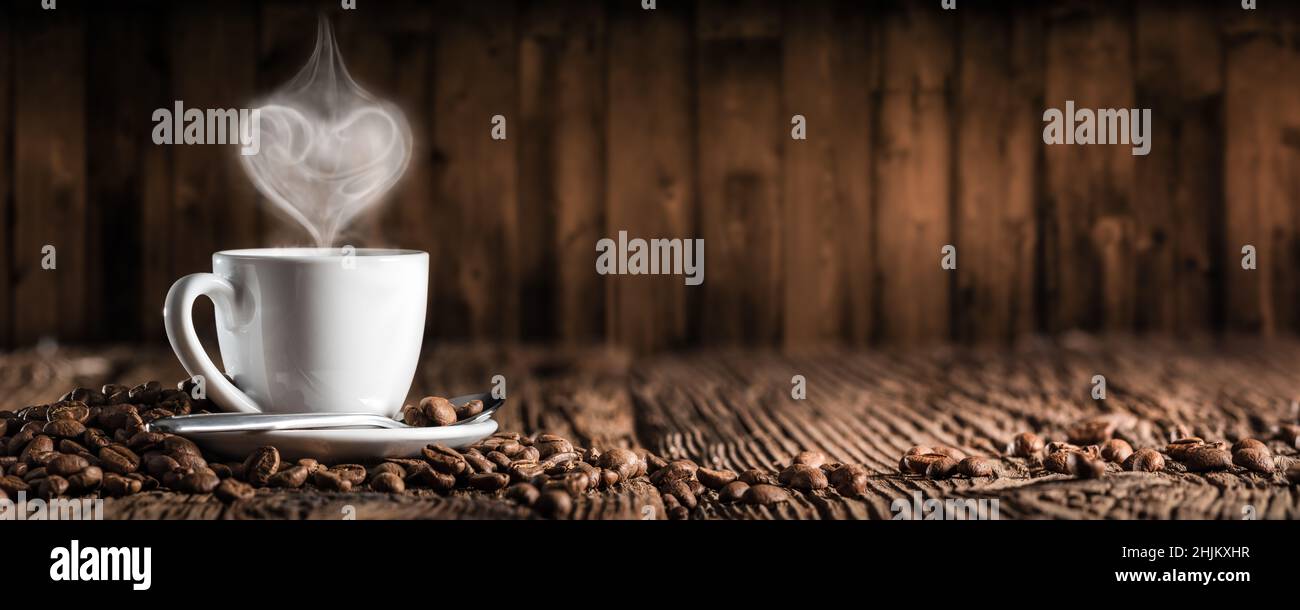 White Espresso Cup And Saucer With Heart Shaped Steam On Wooden Table Stock Photo