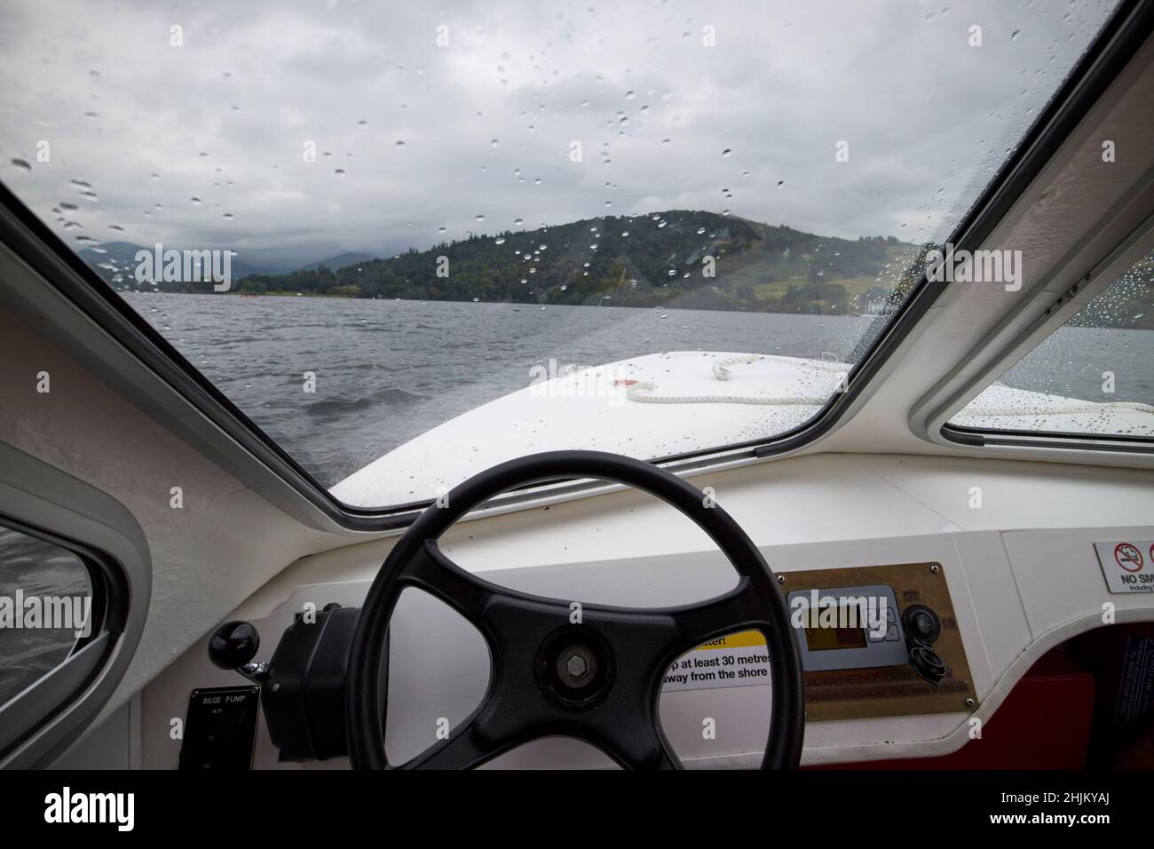 looking out through window steering wheel and power controls on on a electric small boat out on lake windermere lake district, cumbria, england, uk Stock Photo