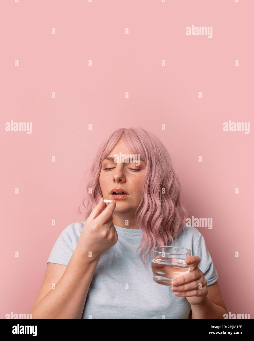 Sick unwell young female drinking water while suffering from migraine