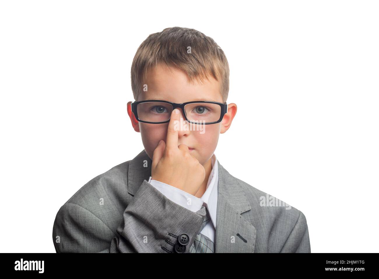Child dressed as an adult businessman straightens glasses with his finger. Face of smart boy in glasses and adult suit isolated on white background. Stock Photo
