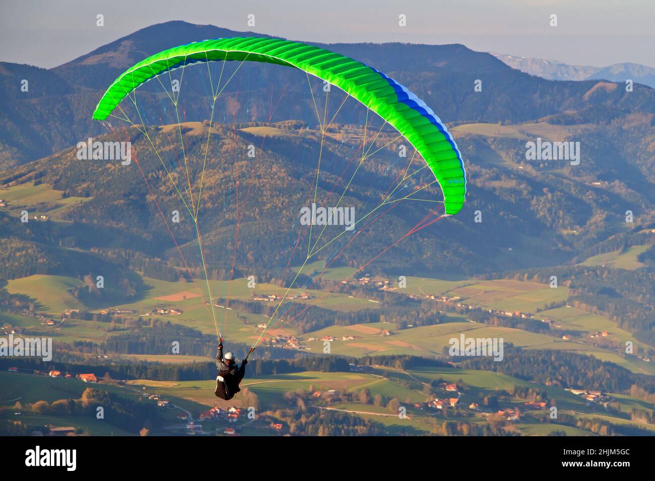 Paraglider departing the Schöckl mountain near Graz in Asutria in beautiful evening light Stock Photo