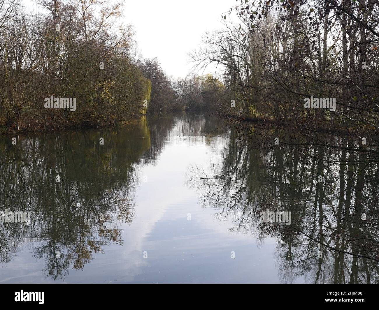 river Tauber in Germany , in autumn on a cloudy day with trees on the shore, reflections on the water Stock Photo