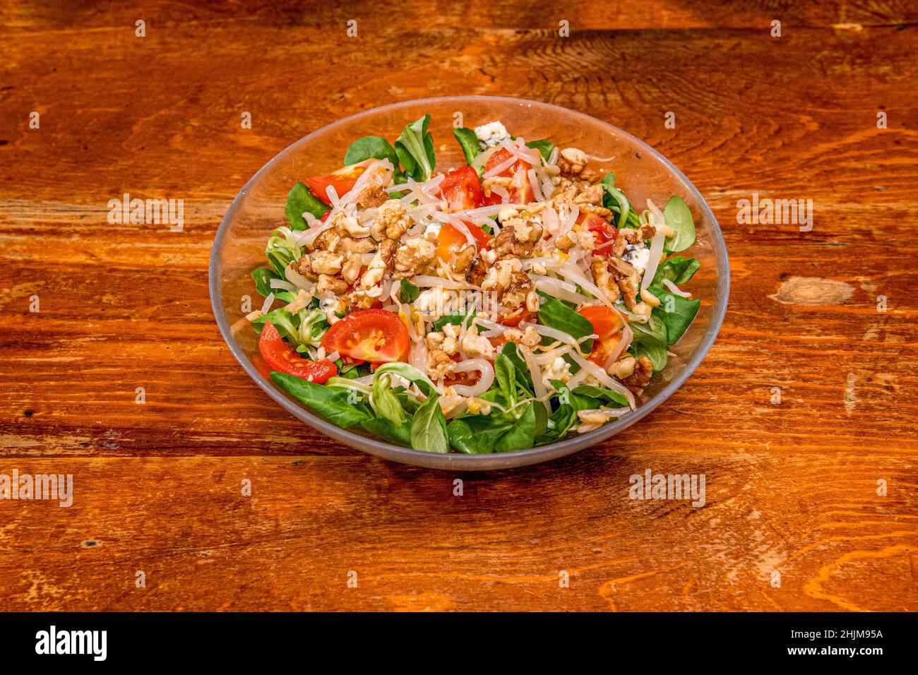Salad concoction with all kinds of ingredients, blue cheese, lamb's lettuce, bean sprouts, cherry tomatoes and walnuts with oil and vinegar Stock Photo