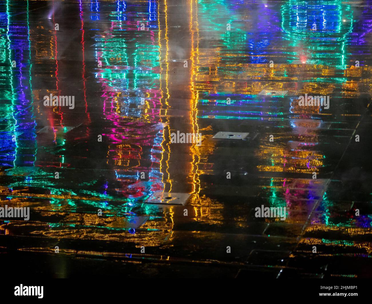 Reflection on the Wet Floor of Colored Lights on a Dark Background Stock Photo