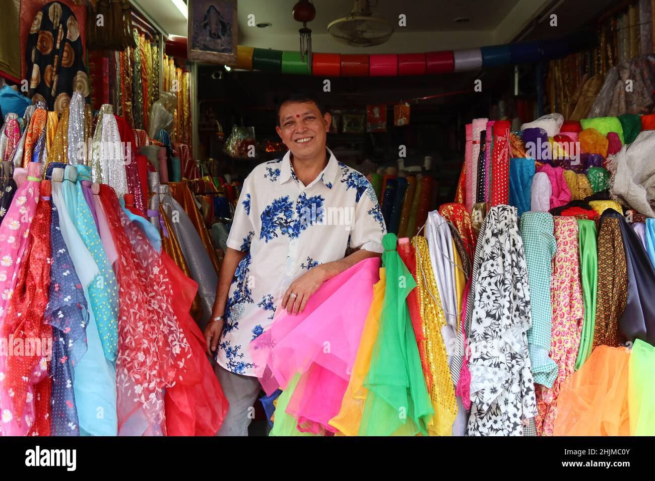 Smiling Textile Seller in one of the many textile stores, Little India, Chinatown, Phahurat, Bangkok, Thailand Stock Photo