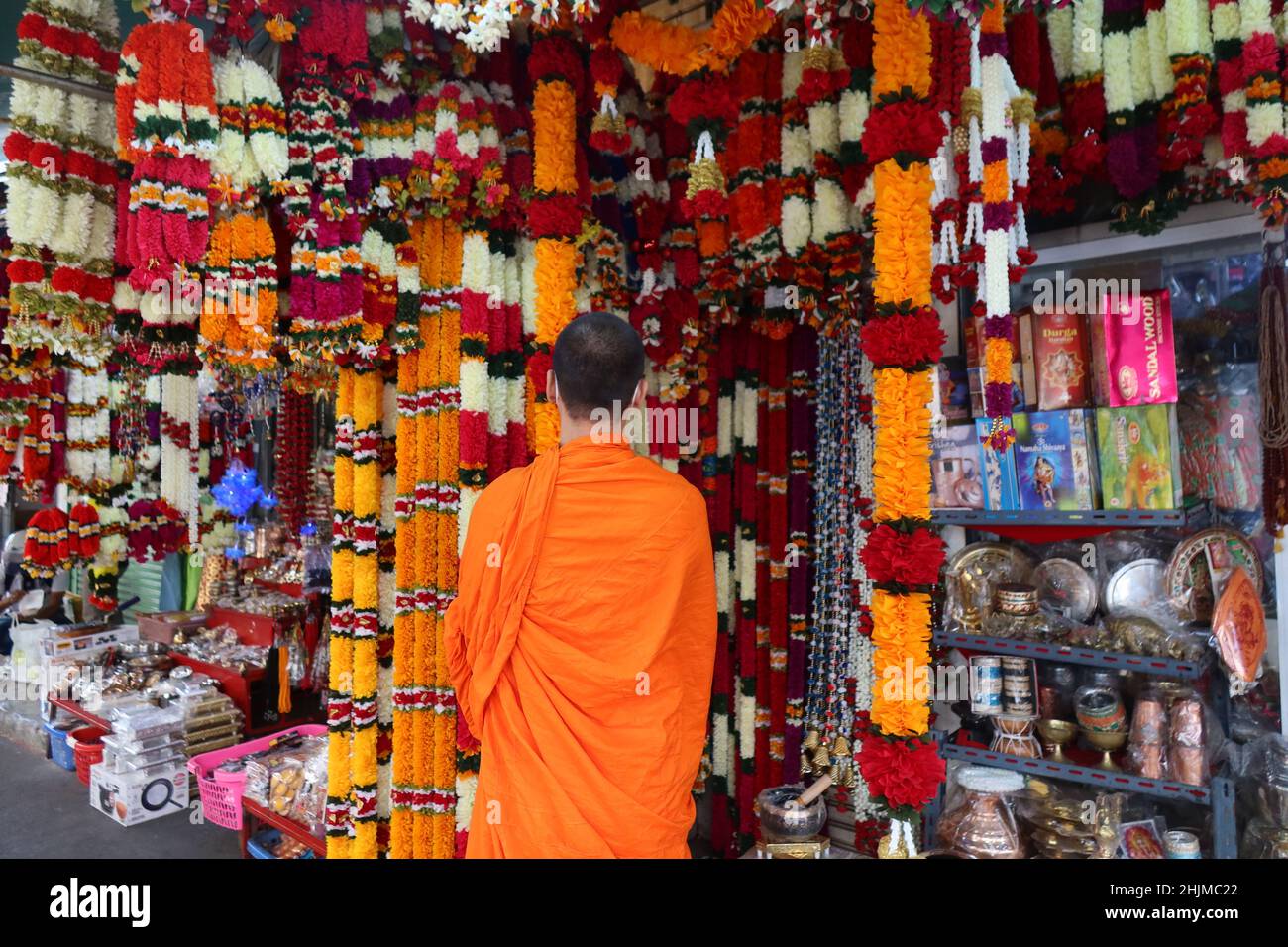 Monk looking at goods in a shop selling Indian Merchandise ,Little India, Phahurat, Chinatown, Bangkok, Thailand Stock Photo