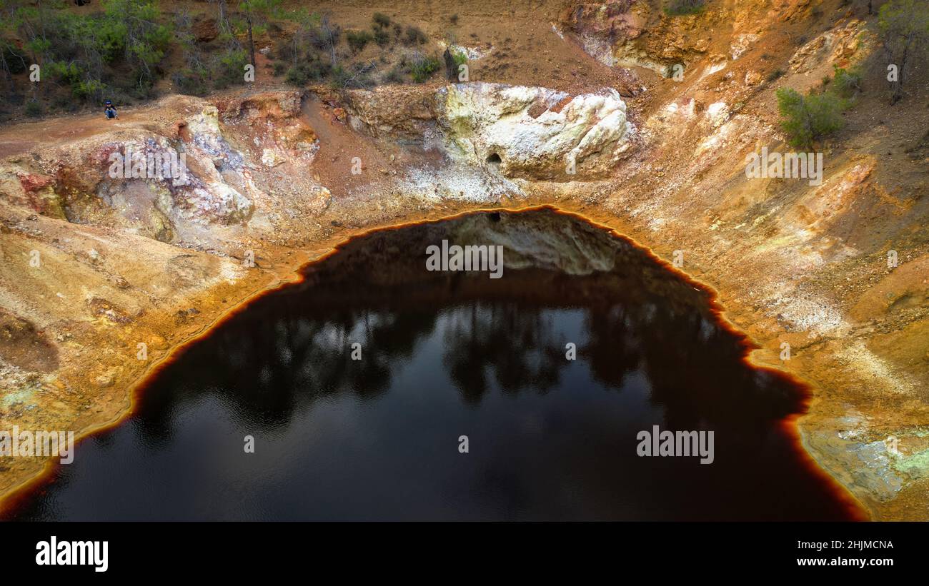 Acidic red lake in Mathatis, Cyprus. Its odd red and yellow colors are the result of the pyrite ore extraction in open pit copper mine Stock Photo