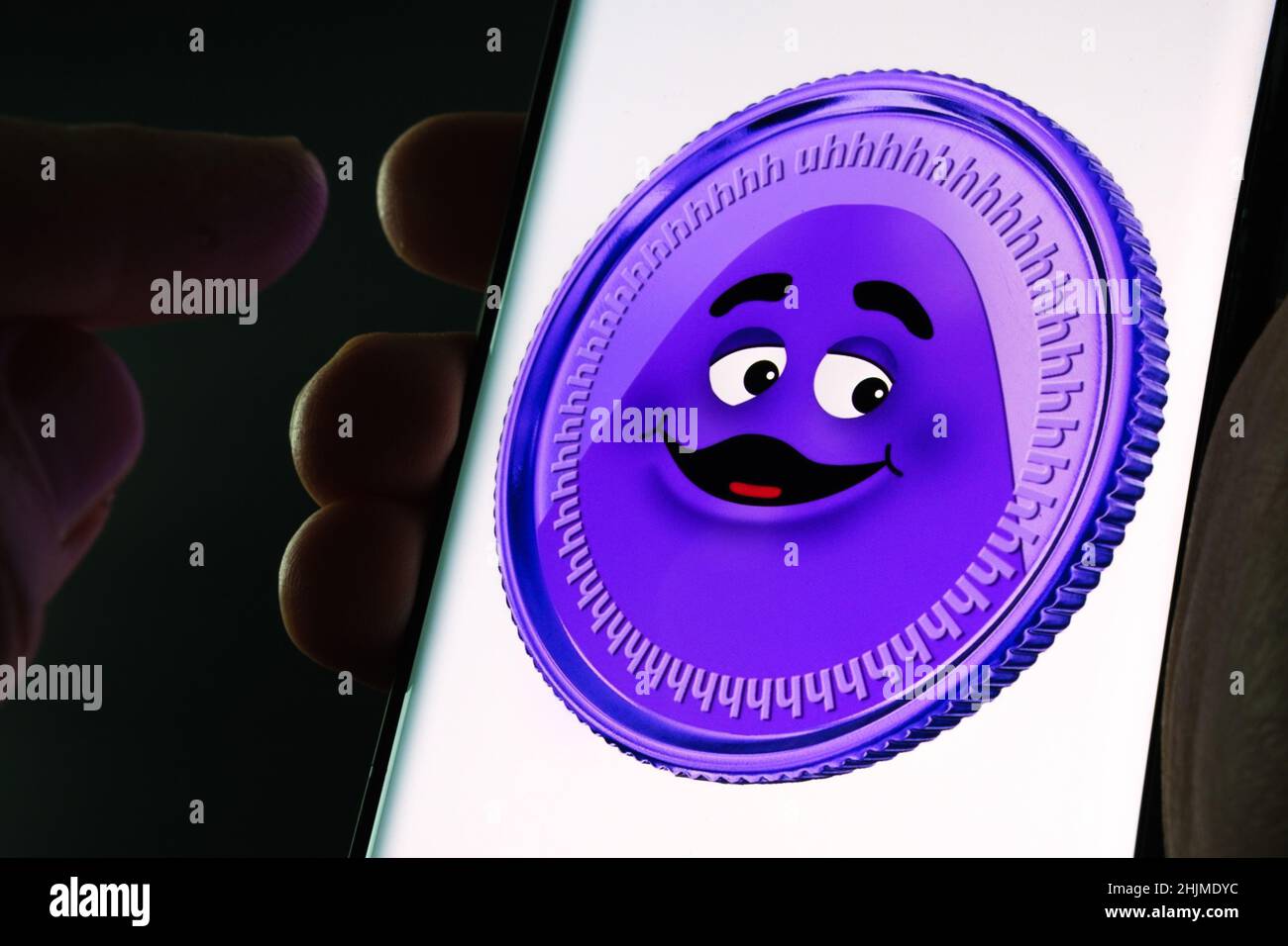 McDonald's Grimace Coin seen on smartphone screen hold in hands. Fake meme coin. Stafford, United Kingdom, January 30, 2022. Stock Photo