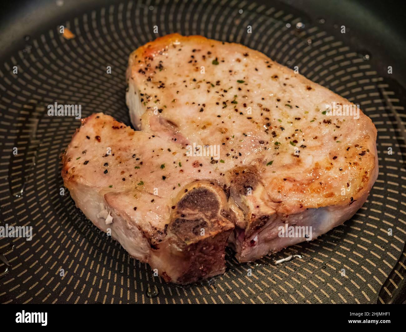 Close up shot of frying pork chop in a nonstick pan at Oklahoma Stock Photo