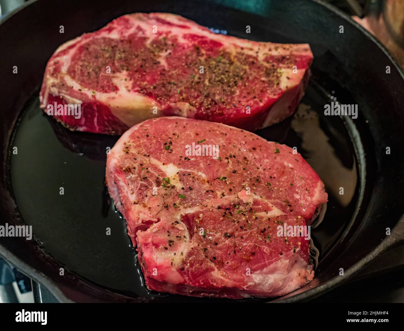 Close up shot of frying aged ribeye steak in a cast iron pan at Oklahoma Stock Photo
