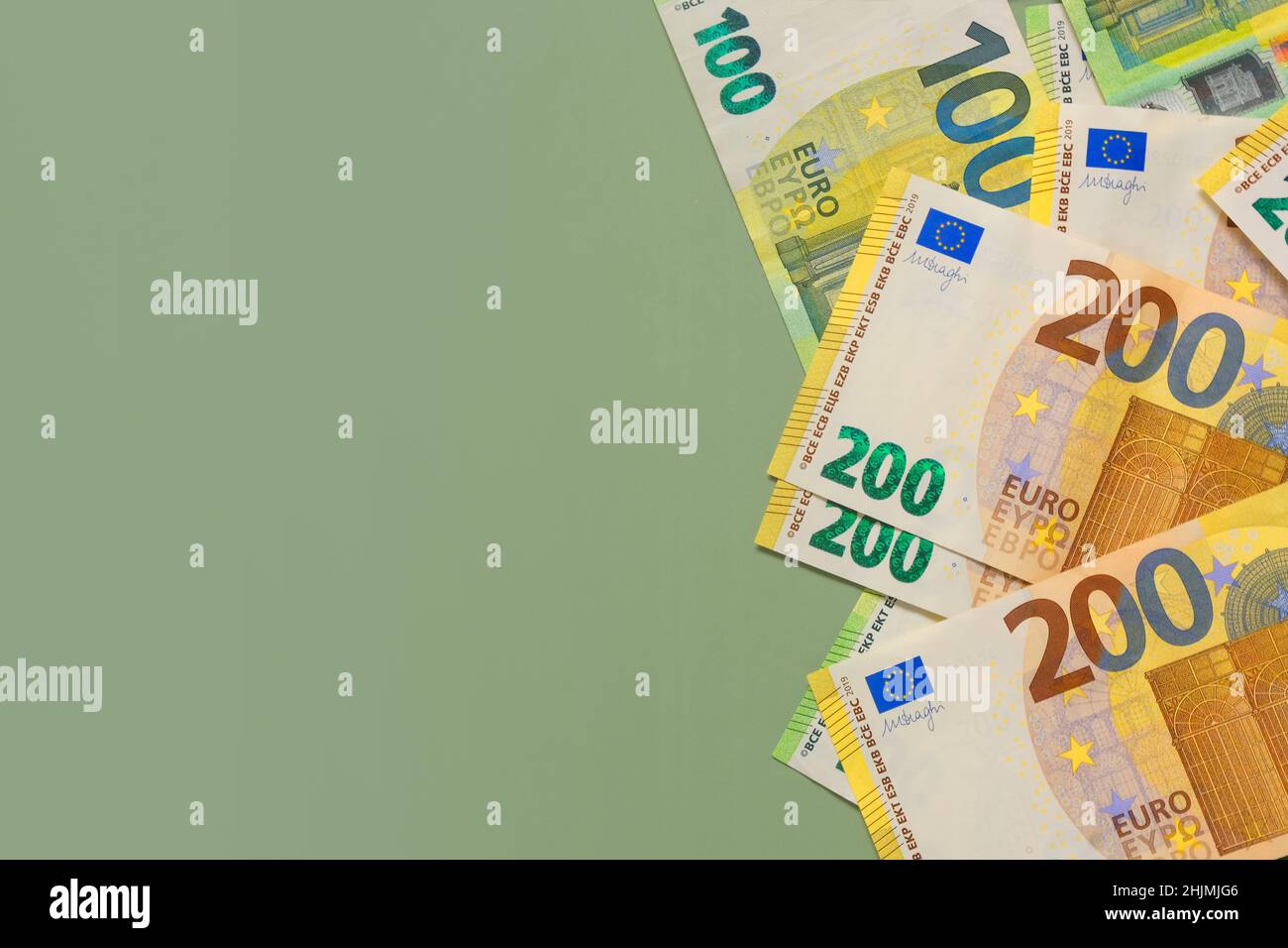 Money background. One and two hundred euro banknotes on a green background.Money and finance.Finance and savings. Stock Photo