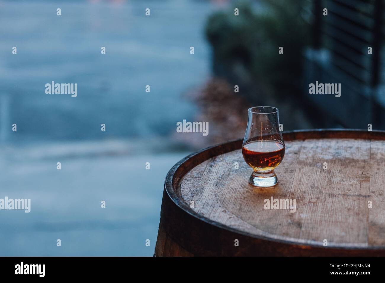 Glencairn glass with whiskey on bourbon barrel Stock Photo