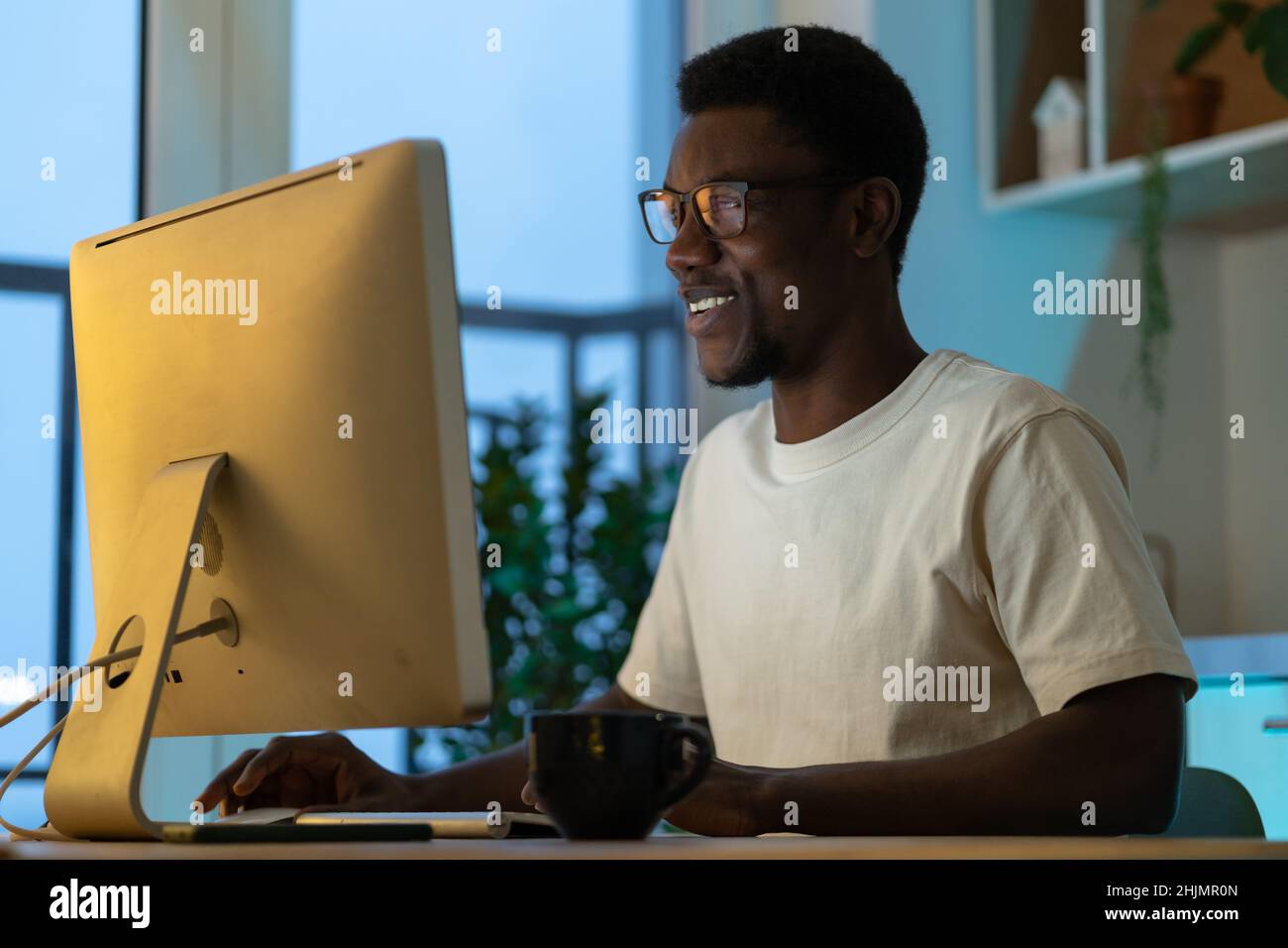 Successful software engineer coding on computer at home late at night enjoy overtime work on startup Stock Photo