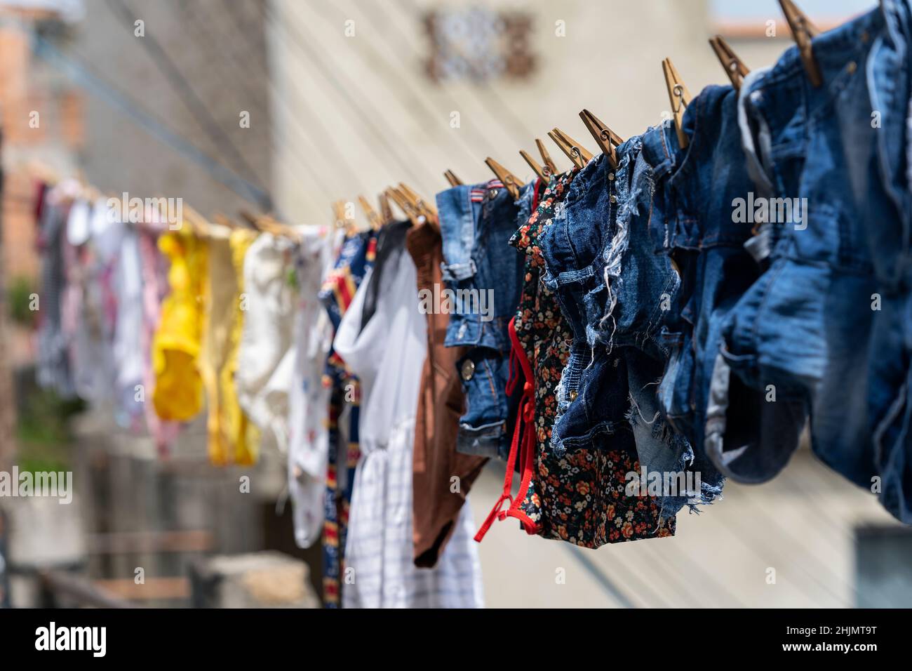 Different clothes hanging on a clothesline. Stock Photo