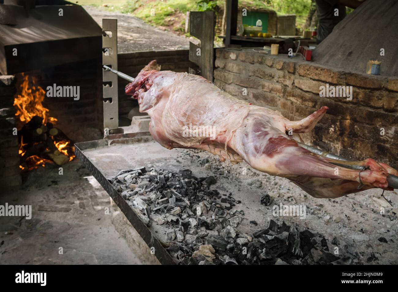 Spit roasting a whole lamb over hot coals Stock Photo