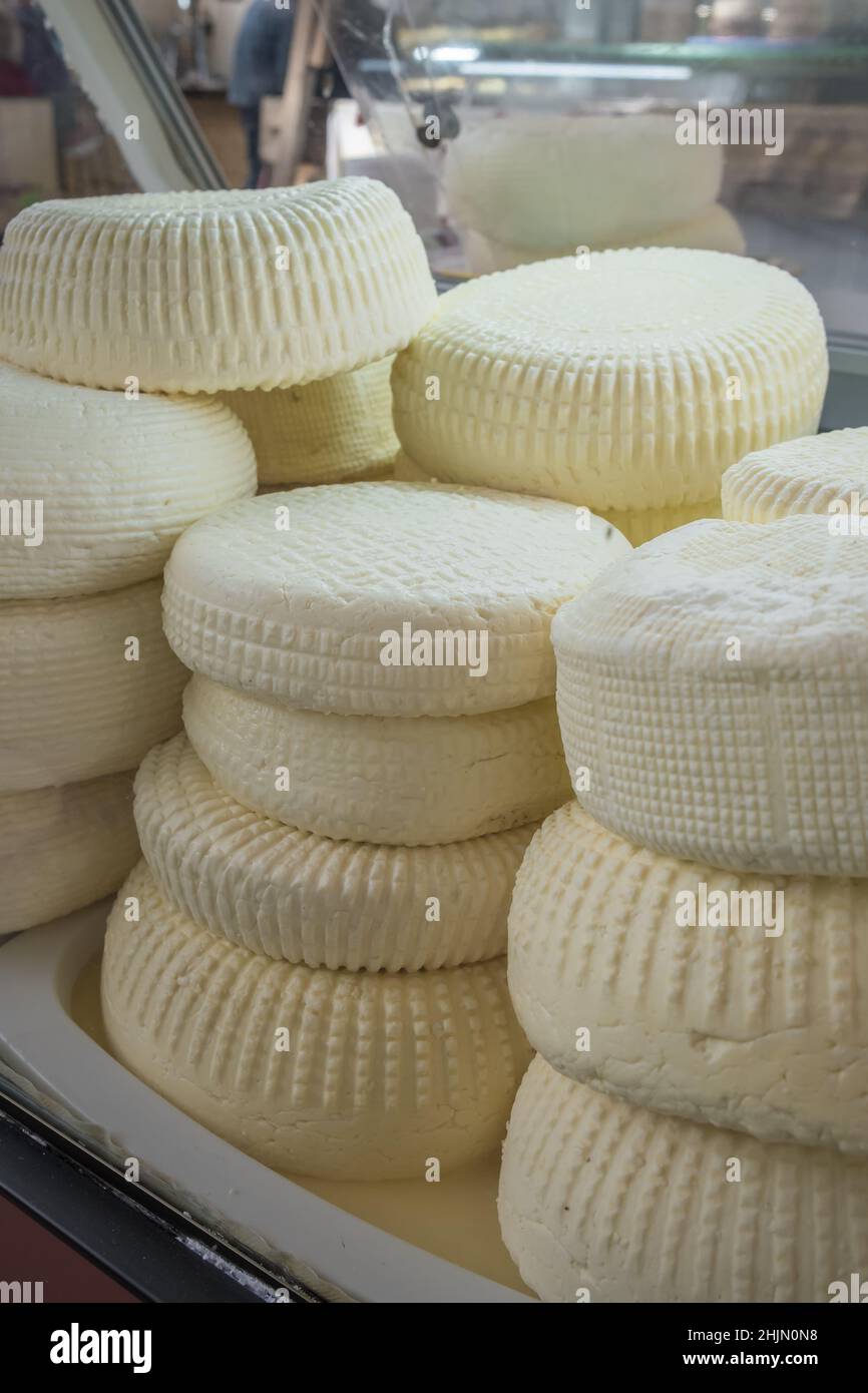 Closeup of piles of round homemade traditional soft cheese in the market in Georgia. Stock Photo