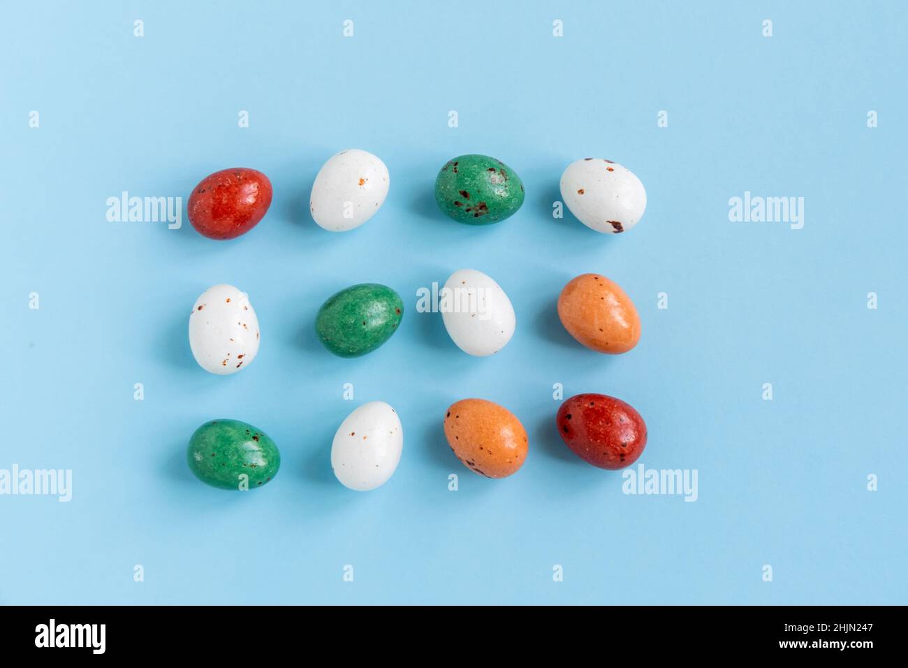 Easter minimal composition with multicolored eggs on the blue background. Easter concept. Flat lay. Stock Photo