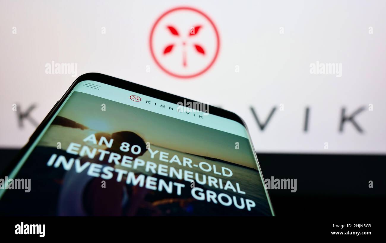 Mobile phone with website of Swedish investment company Kinnevik AB on screen in front of business logo. Focus on top-left of phone display. Stock Photo