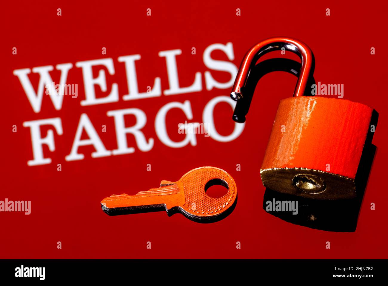 An open security lock and key on background of Wells Fargo bank logo in