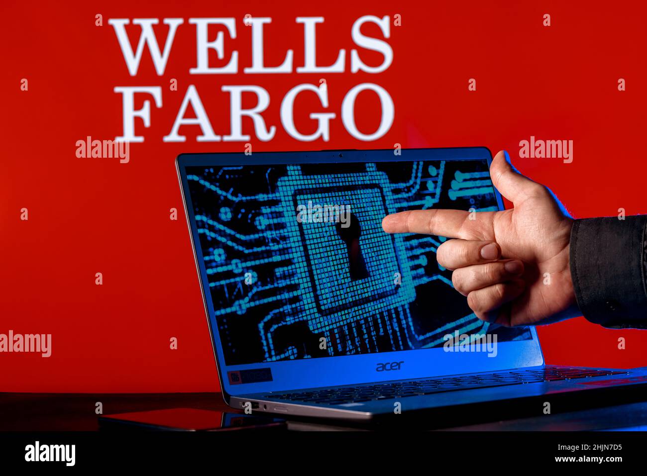 Laptop with lock symbol on screen on background of  Wells Fargo bank logo. Finger points to lock symbol. Concept of data hacking. Stock Photo