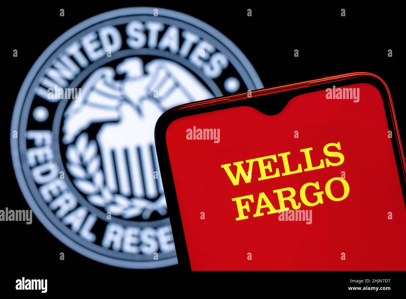 Smartphone with Wells Fargo bank logo on background of Federal Reserve symbol Stock Photo