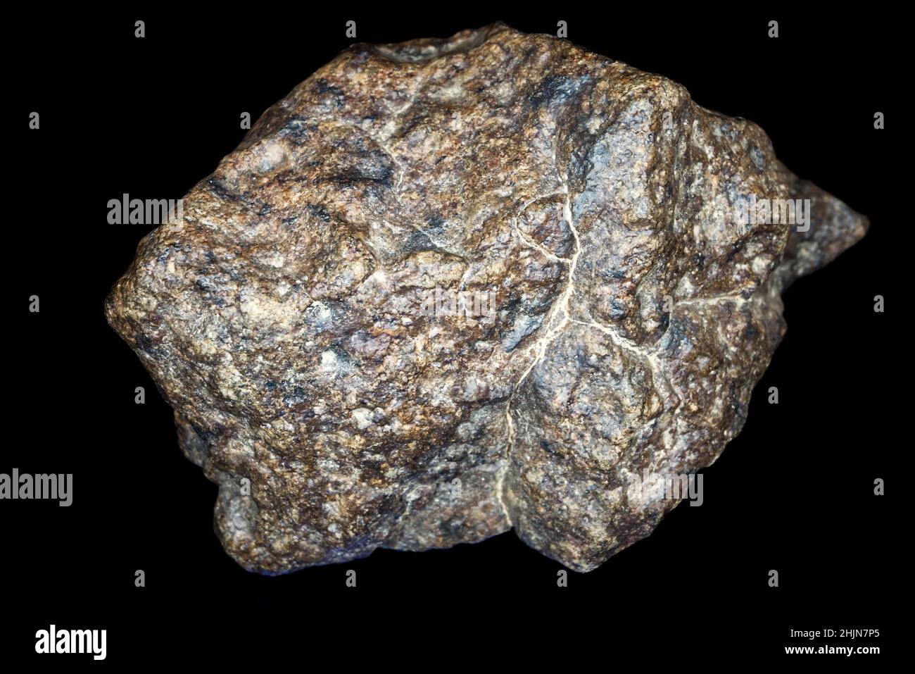 Chondrite Meteorite stone isolated on black background. Piece of rock formed during the Solar System creation. Stock Photo