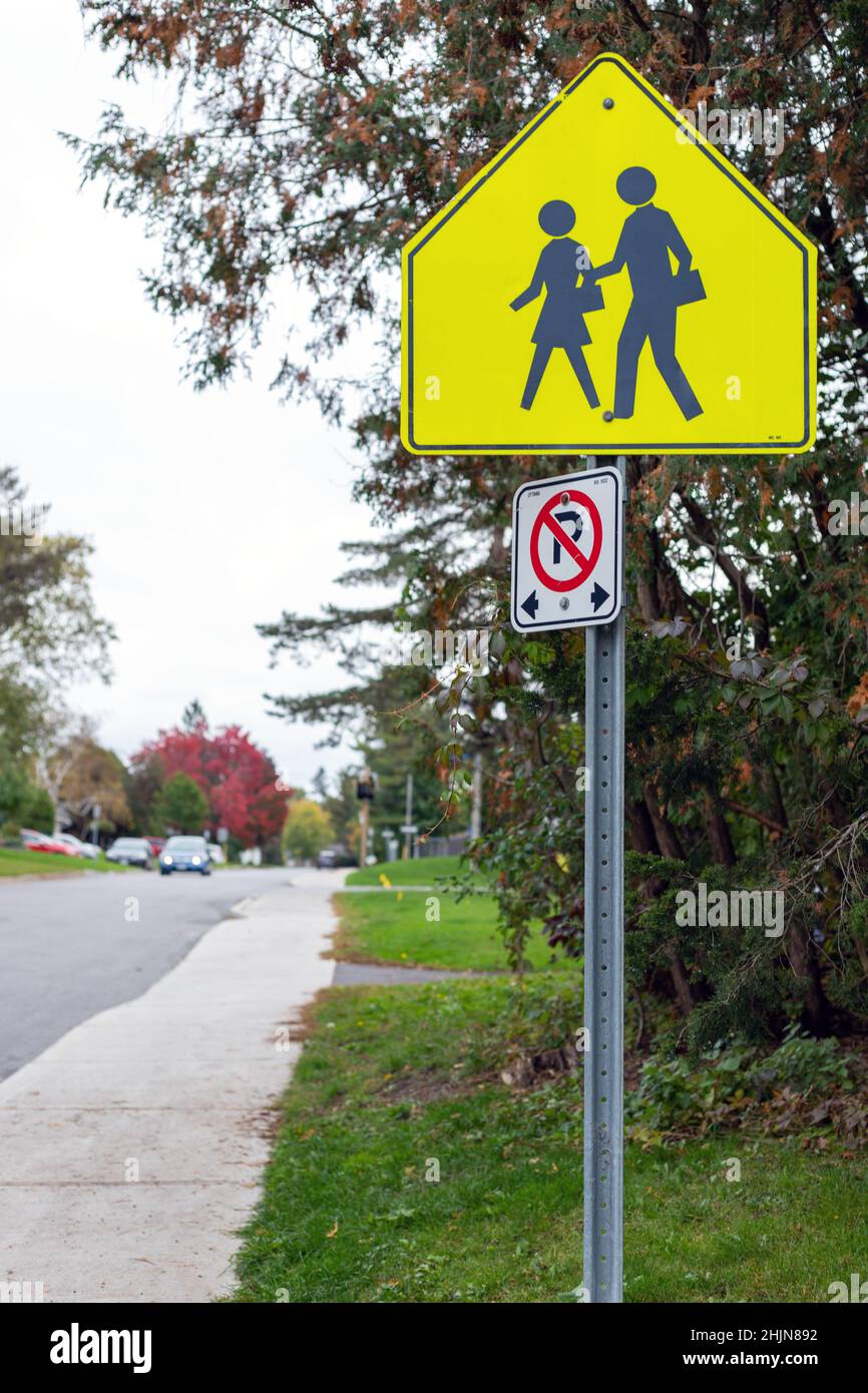 Ottawa, Canada - October 10, 2021: Yellow school crossing ahead sign on the road near school zone Stock Photo