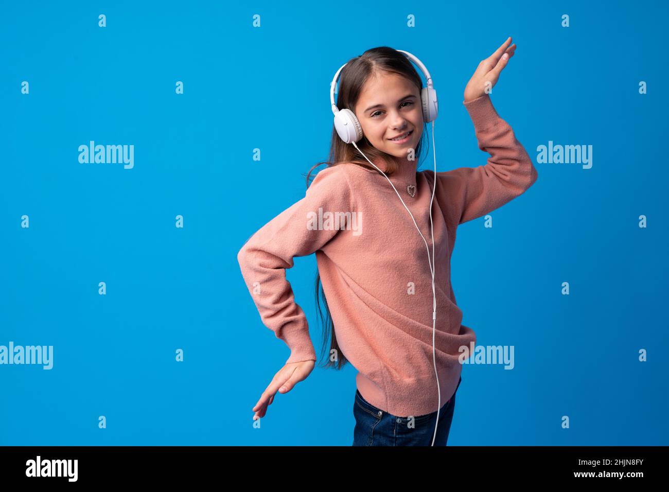 schoolgirl-with-headphones-listening-to-music-against-blue-background