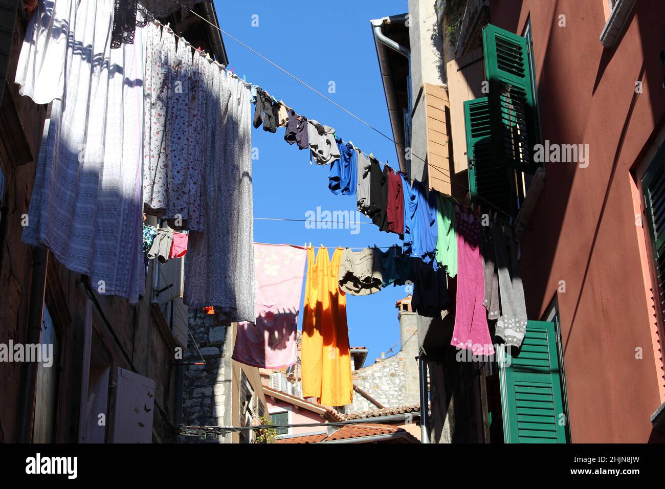 Low angle shot of clothes hanging on a clothesline between buildings in