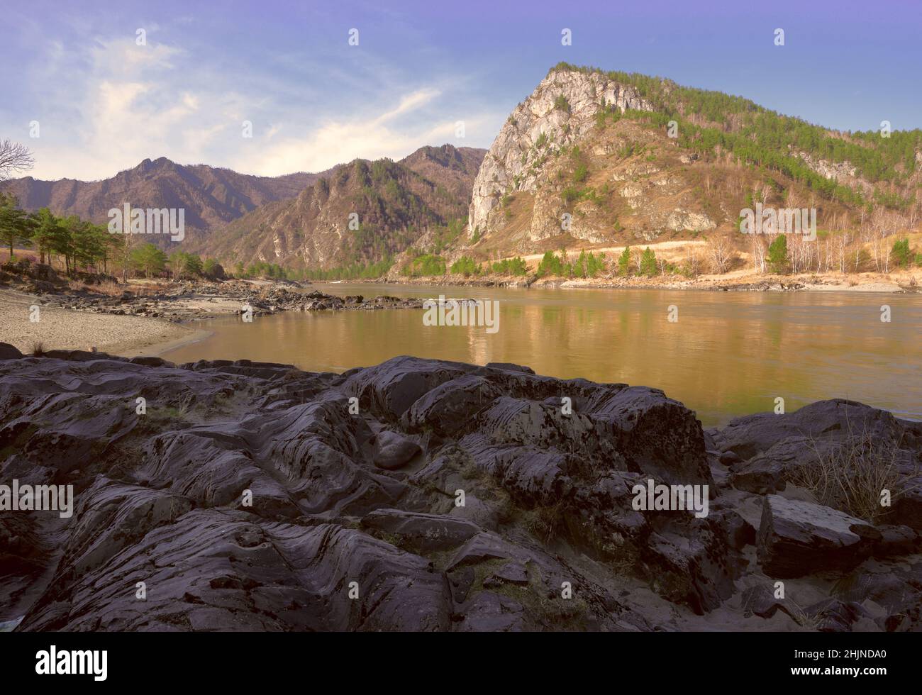 Wavy layered rocks on the Bank of a mountain river. Geological ...