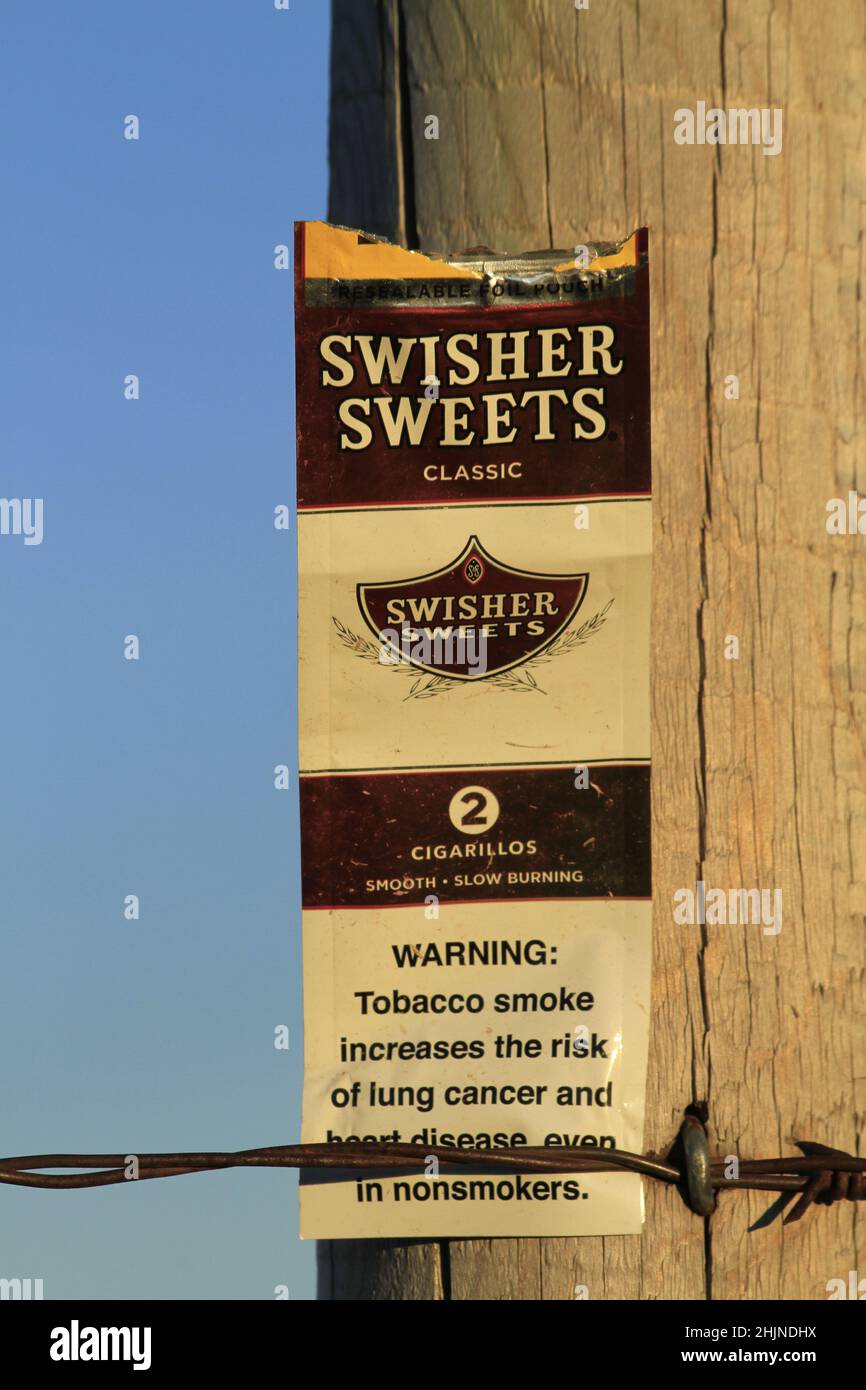 SWISHER SWEETS on a pole with blue sky out in the country Stock Photo