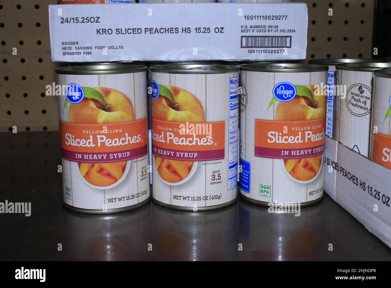 A closeup shot of Sliced Peaches in cans on a metal shelf at a Dillons grocery store Stock Photo